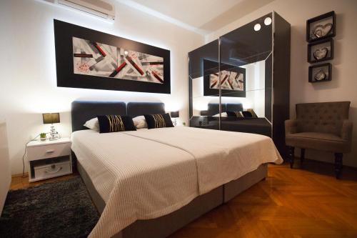 奥西耶克Apartman Aurelius - private parking的一间卧室配有一张大床和一把椅子