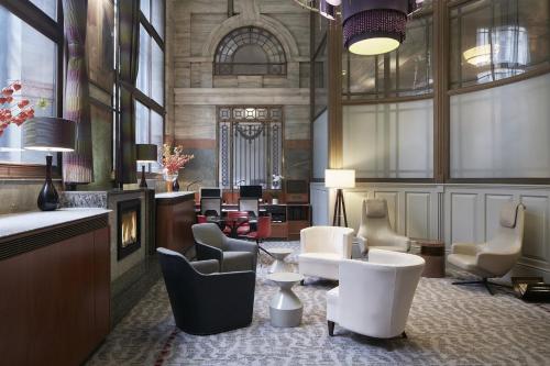 伦敦Club Quarters Hotel London City, London的大堂设有椅子和壁炉等候区