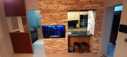 斯科普里Apartment Nenov的厨房设有砖墙上的电视