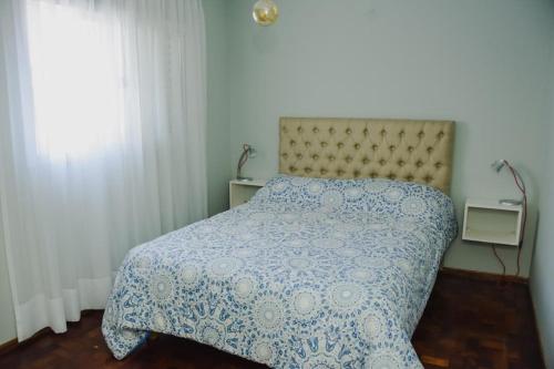 科尔多瓦Departamento centro Cordoba capital的一间卧室配有一张带蓝色和白色棉被的床