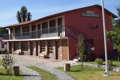 瓦斯卡坎波Hotel La Casona Real的一座红色的建筑,旁边设有阳台