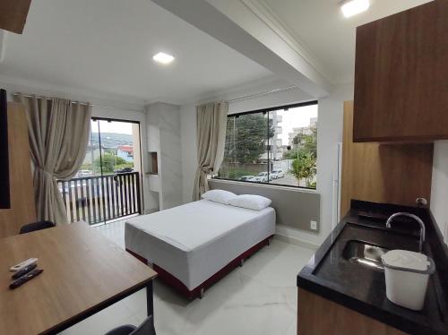 邦比尼亚斯Residencial Batista的一间卧室配有一张床,厨房配有水槽