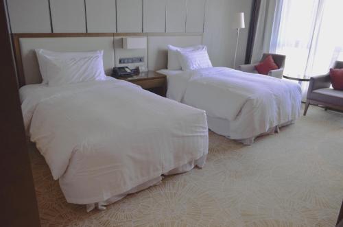 上海新桥绿地铂骊酒店客房内的一张或多张床位