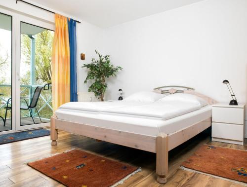 KirchdorfMann un Fru - Residenz am Yachthafen的一间卧室设有一张床和一个阳台
