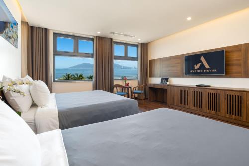 岘港Avenis Hotel的酒店客房设有两张床和一台平面电视。