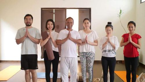 瑞诗凯诗Yogi Home Stay的一群人在房间里做瑜伽