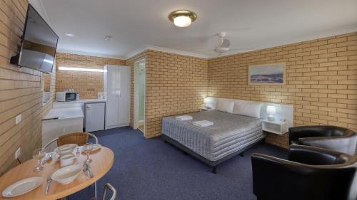 贡迪温迪嘉西德汽车旅馆的酒店客房设有一张床铺、一张桌子和一间厨房。