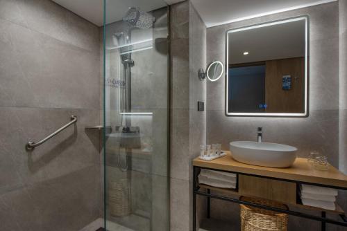 上海Park Inn by Radisson Shanghai Global Harbor的一间带水槽和玻璃淋浴的浴室