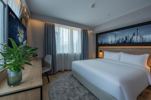 上海Park Inn by Radisson Shanghai Global Harbor的卧室配有一张白色大床和一张书桌