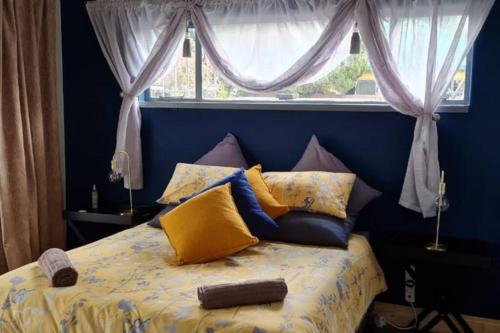 帕雷斯Casa Bianco: Affordable luxury - Self Catering House的一张带黄色和蓝色枕头的床和窗户