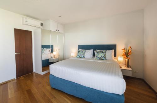华欣First Choice Grand Suites Sha Plus Extra的一间卧室配有一张大床和两盏灯。