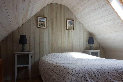 LopérecCleuziou Vraz的一间卧室配有一张床和两张带台灯的桌子。
