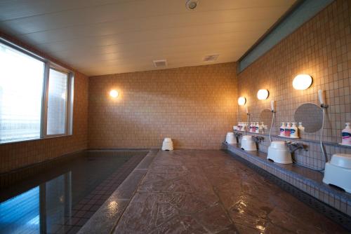 白山市白山格兰德酒店的浴室配有盥洗盆、镜子和浴缸。