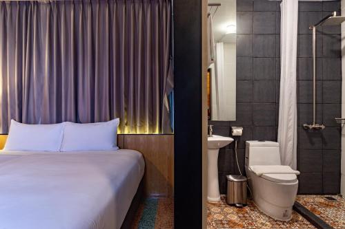 曼谷布拉纱里W22酒店【SHA Plus+】的一间卧室配有床、水槽和卫生间