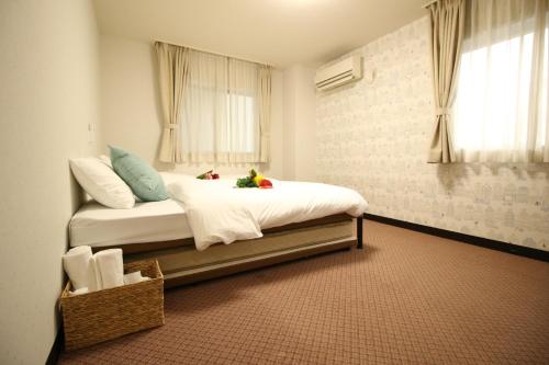 东京Okubo Hotel Hawaii的一间卧室配有一张带白色床单的床和一扇窗户。