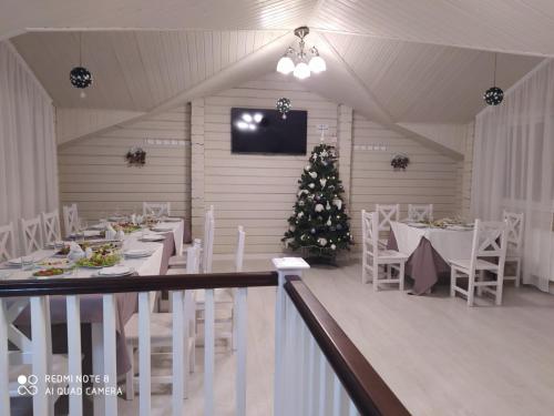 斯拉夫西克Pogar White的一间用餐室,配有圣诞树和白色的桌椅