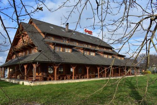 Týniště nad OrlicíMotel Roubenka的一座大型木制建筑,设有黑色屋顶