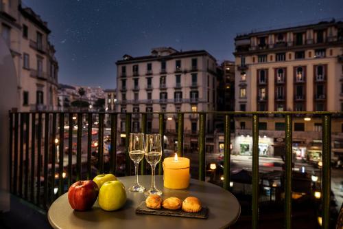 那不勒斯Demart Suites的阳台上的桌子上放着蜡烛和酒杯
