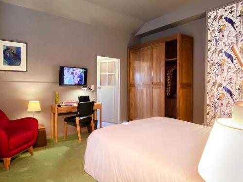 桑利斯美妙旅馆的一间卧室配有一张床、一张红色椅子和一张书桌
