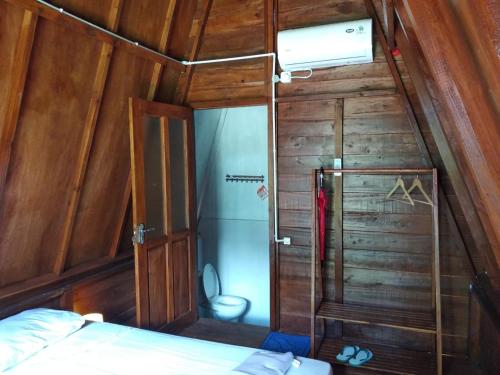 SijukTanjong Tinggi Cottage的小房间设有床和木墙
