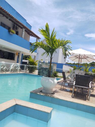 里约达欧特拉斯马雷西亚科斯塔阿苏尔旅馆的一座带椅子的游泳池,一座棕榈树旁边