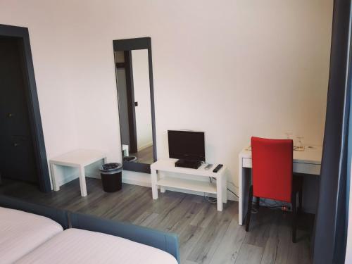 拉绍德封弗乐德里斯酒店 的客房设有书桌、电脑和红色椅子
