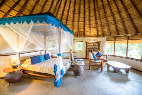 MbitaMfangano Island Lodge的一间卧室,卧室内配有一张天蓬床