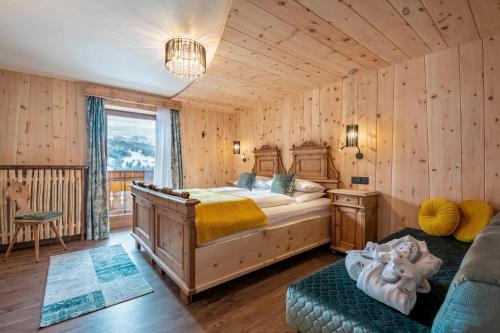 塞尔瓦迪加尔代纳山谷Hotel Jägerheim 3S的卧室配有一张床铺,位于带木墙的房间内