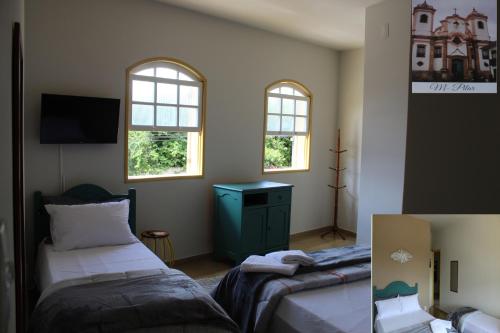 欧鲁普雷图Vila Marias的一间卧室设有两张床和两个窗户。