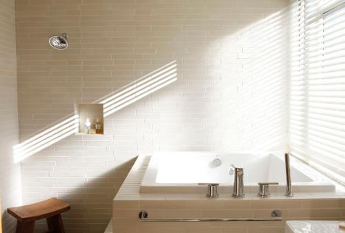 希尔兹堡H2酒店的白色的浴室设有浴缸和水槽。