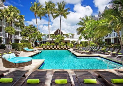 基韦斯特Opal Key Resort & Marina的度假村的游泳池配有躺椅和棕榈树