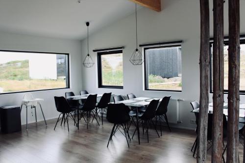 Sandgerði爱思戴小屋酒店的用餐室设有桌椅和窗户。