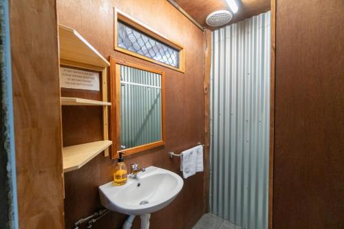 赫维湾Woolshed Eco Lodge的一间带水槽和镜子的浴室以及窗户。