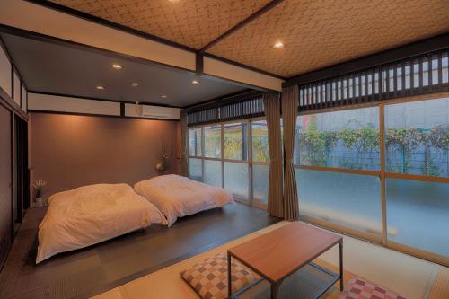 富士河口湖Yoshimura ooike sense的卧室配有床、桌子和窗户。