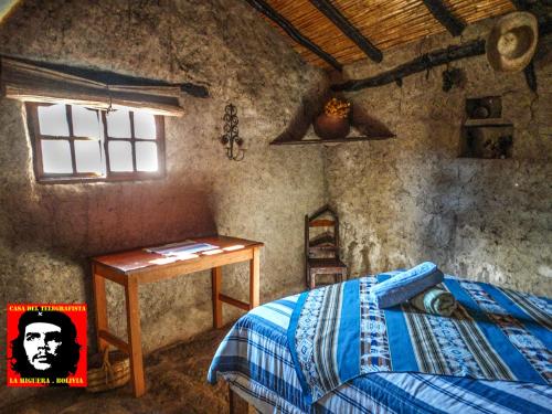 La HigueraCasa del Telegrafista的一间卧室配有一张床、一张桌子和一个窗户。