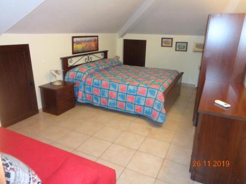 菲乌梅夫雷多迪西奇利亚nonna melina的一间卧室配有一张床和一张红色的沙发