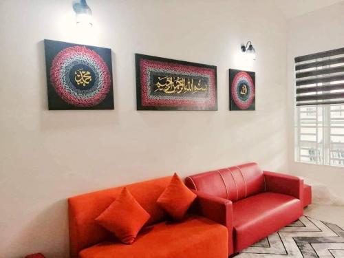 宋溪Nur Zahra Sungkai Homestay的客厅里一张红色的沙发,上面有四张照片