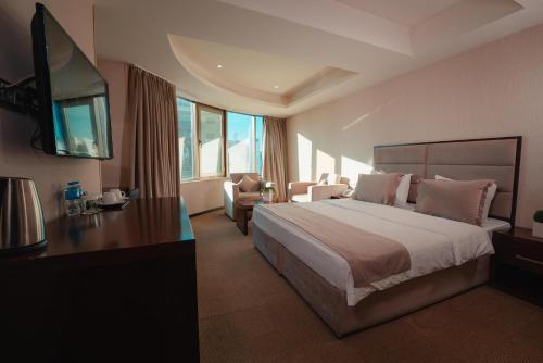 苏莱曼尼亚Mihrako Hotel & Spa的酒店客房设有一张大床和一台电视。
