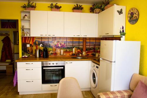 内塞伯尔Апартамент Lavander Fleur的厨房配有白色橱柜和白色冰箱。