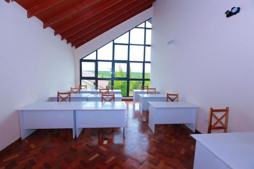 Naro MoruMtoni Resort, Naro moru的客房设有桌椅和大窗户。