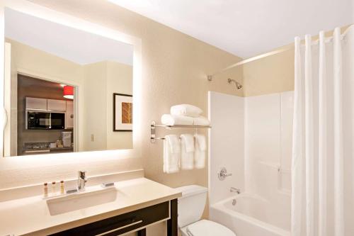 奥兰多MainStay Suites Orlando Altamonte Springs的一间带水槽、卫生间和镜子的浴室