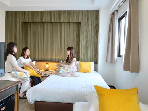 大分大分一区酒店的三个女人坐在旅馆房间的床边