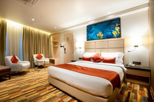 罗纳瓦拉The Orchid Lonavala的酒店客房设有一张大床和一张书桌。