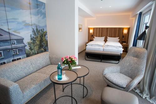 施马伦贝格佳德豪斯维泽酒店的客厅配有沙发、两把椅子和一张床