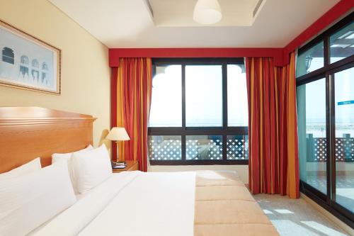 迪拜罗达海滩度假村的一间卧室设有一张床和一个大窗户