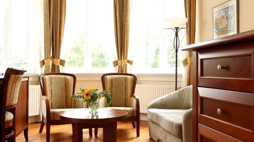 米兹多洛杰斯特拉马里斯别墅公寓式酒店的客厅配有桌子、两把椅子和一张沙发