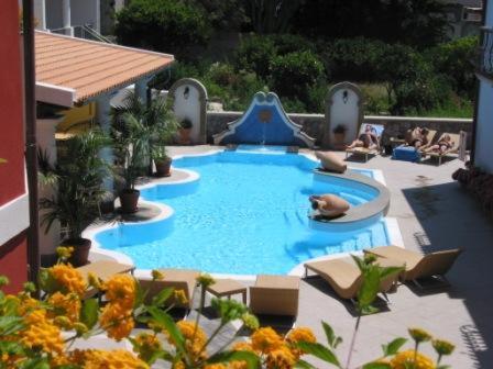利帕里菲奥伦蒂诺别墅酒店的一个带滑梯的大型游泳池,周围的人坐在游泳池周围