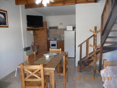 本塔纳山村Cabañas Aldea Serrana的厨房以及带木桌和椅子的用餐室。
