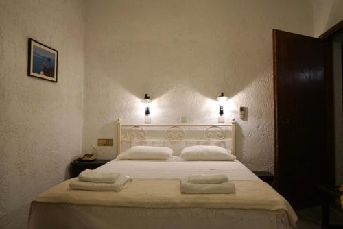 GrikosAlexandros Hotel的卧室配有带毛巾的大型白色床