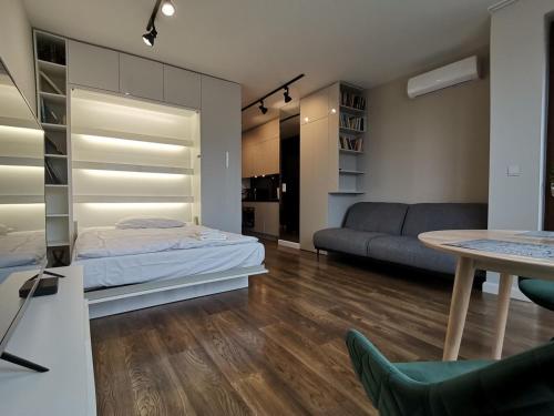 华沙Nowoczesny Apartament z widokiem的客厅配有床和沙发